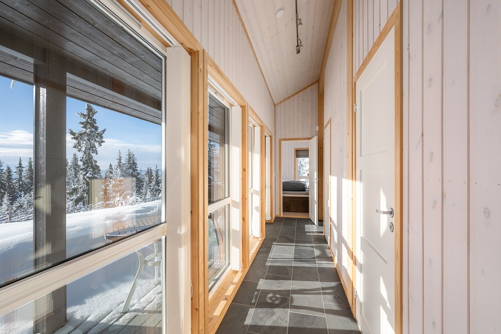 Gangen binder sammen soveromsavdelingen med stuen og har flislagt gulv med varme. Galleribilde