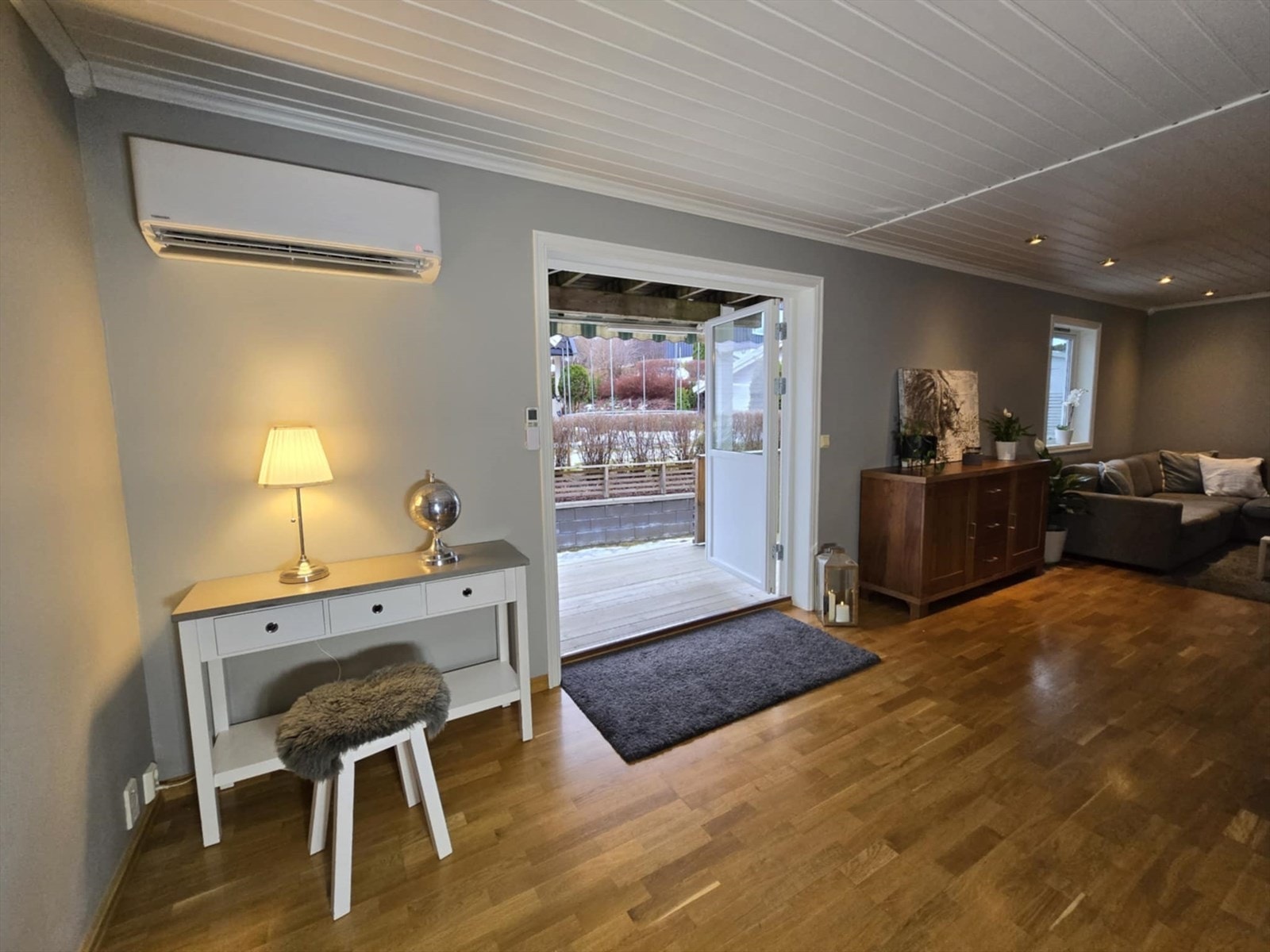 Romslig stue med dobbel terrassedør ut til terrassen. I stuen er det også montert varmepumpe på vegg, samt down-lights i himling. Galleribilde