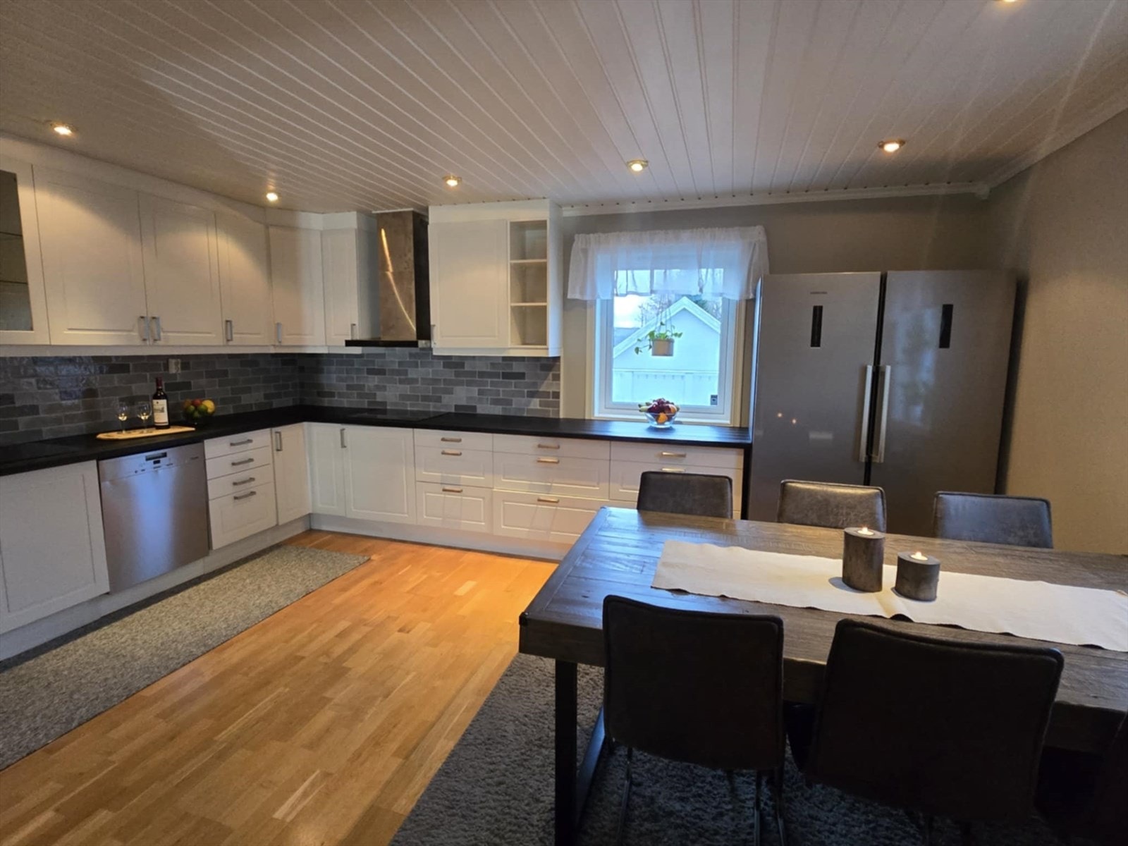 Kjøkkeninnredningen har hvite, profilerte fronter og laminert benkeplate. Galleribilde