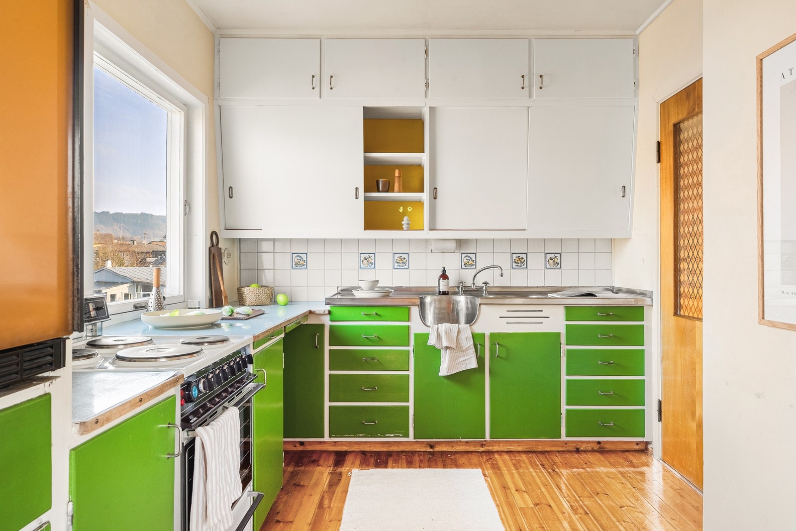 Kjøkkenet måler 8 kvm, har opprinnelig plassbygget kjøkkeninnredning med slette fronter og laminert benkeplate. Galleribilde