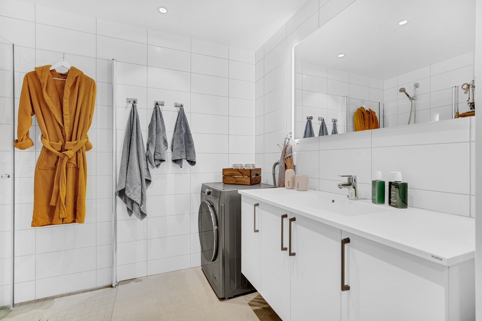 Badet har flislagte overflater og behagelig gulvvarme. Det er god belysning fra downlights i himling og integrert lys i speil. Galleribilde