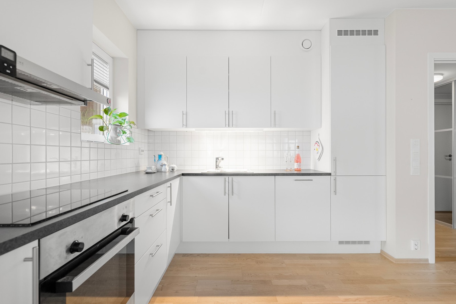 På kjøkkenet har du lys innredning med slette fronter, og fliser mellom benk og overskap som gjør renholdet enkelt. Galleribilde