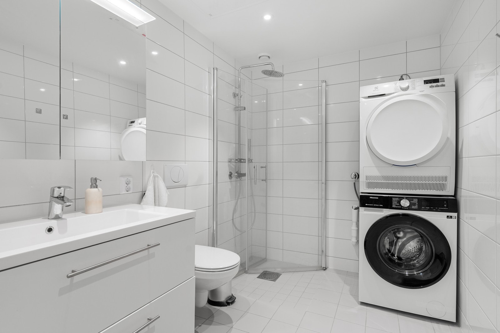 Elegant helfliset bad med varme i gulvet og downlightst i tak og i speilskap Galleribilde