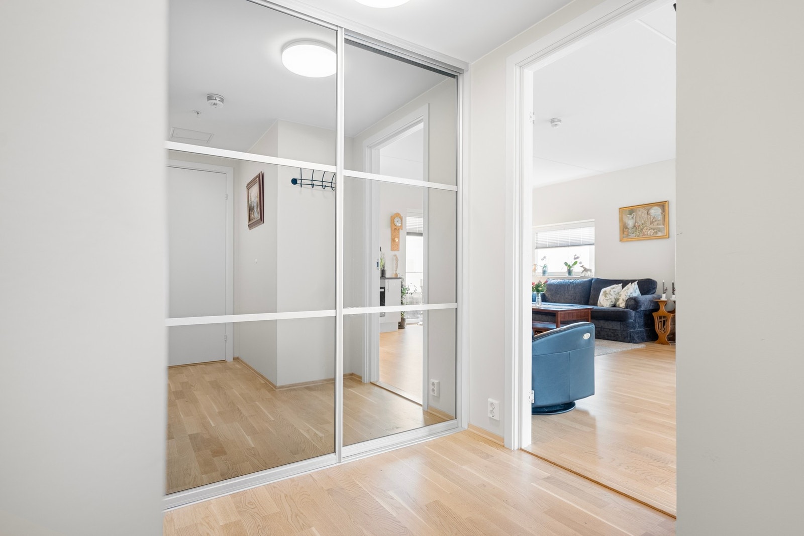 Romslig entré med skyvedørsgarderobe med speildører, som gir en følelse av et større og mer åpent rom Galleribilde