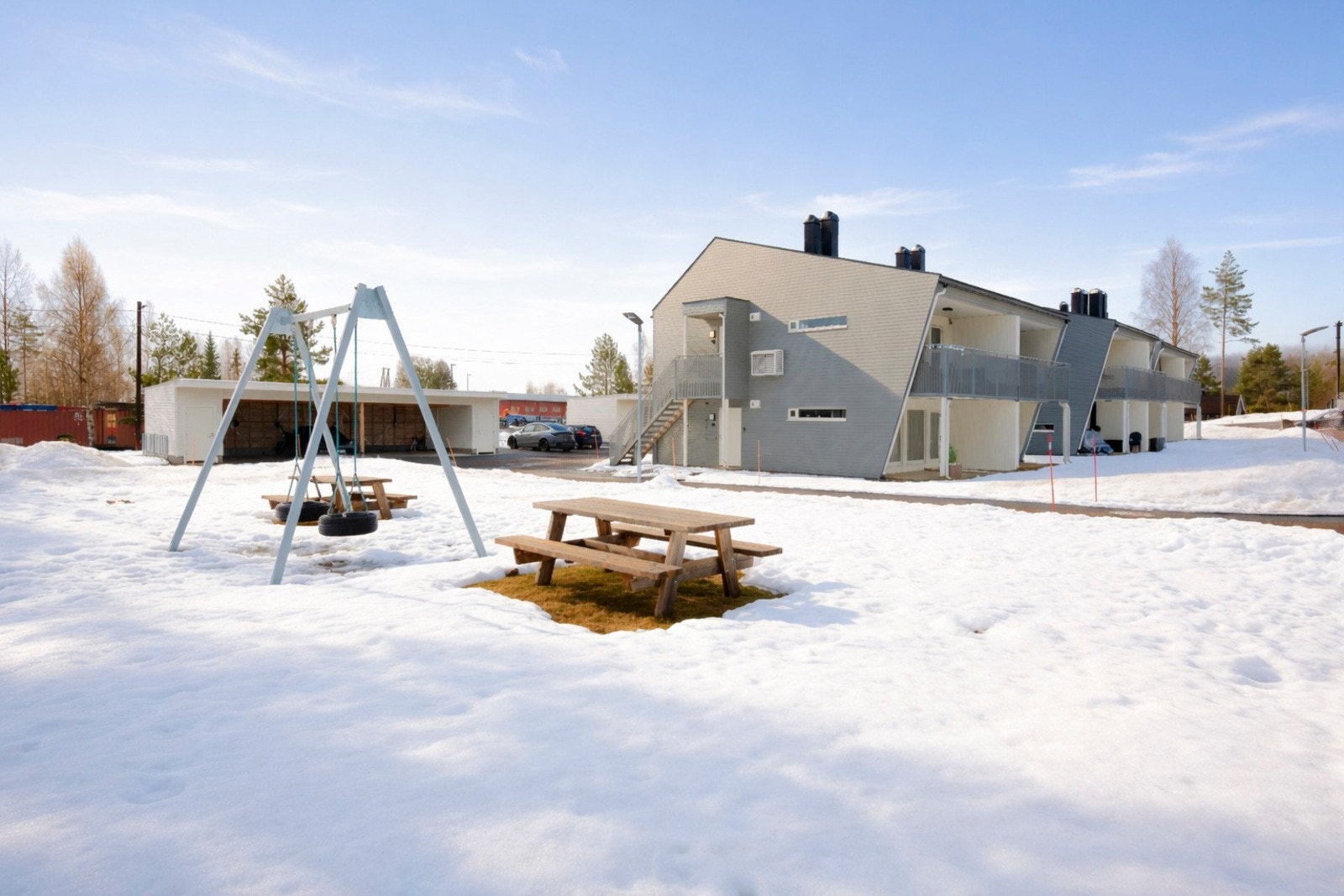 Pen fasade med koselig benk og lekearealer for barn. Galleribilde