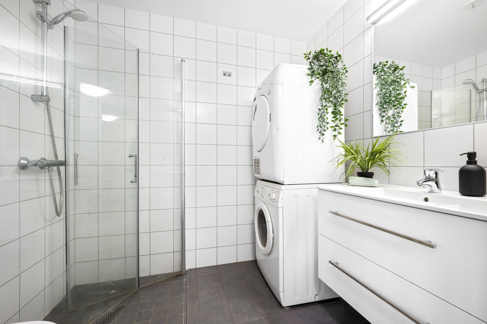 Stilrent bad med hvite fronter, servant og speil med belysning Galleribilde