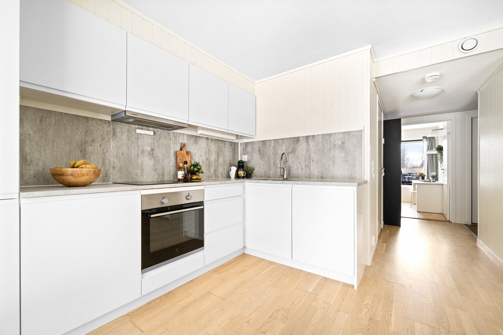 Pent og tidsmessig kjøkken med hvite fronter og grå laminatbenkeplate - en stilren kombinasjon som gir et lyst og moderne uttrykk. Galleribilde