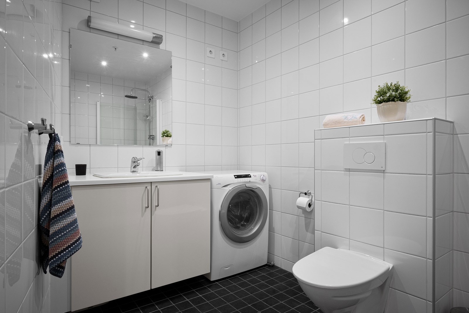 Pent og tidløst, helfliset bad med varmekabler på gulv. Vegghengt toalett. Hvit innredning. Galleribilde