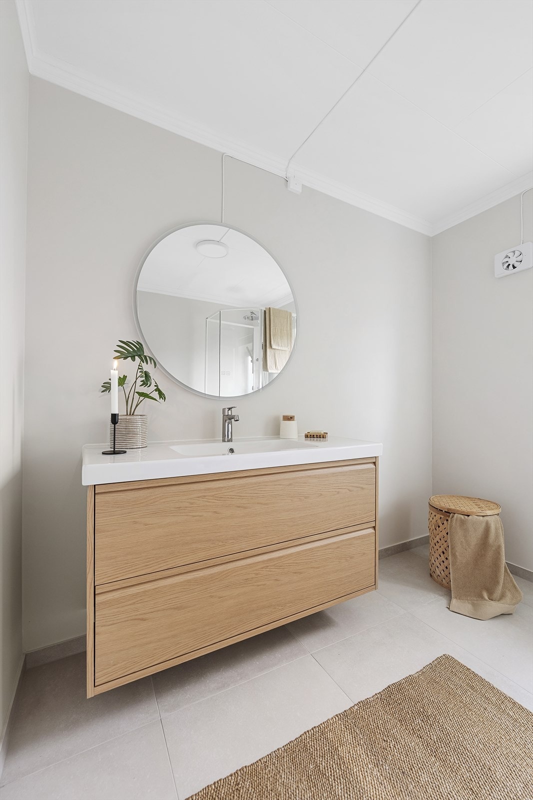 Badet er utstyrt med veggmontert toalett, dusjkabinett og opplegg for vaskemaskin. Ventilasjon via el-ventil i vegg. Galleribilde