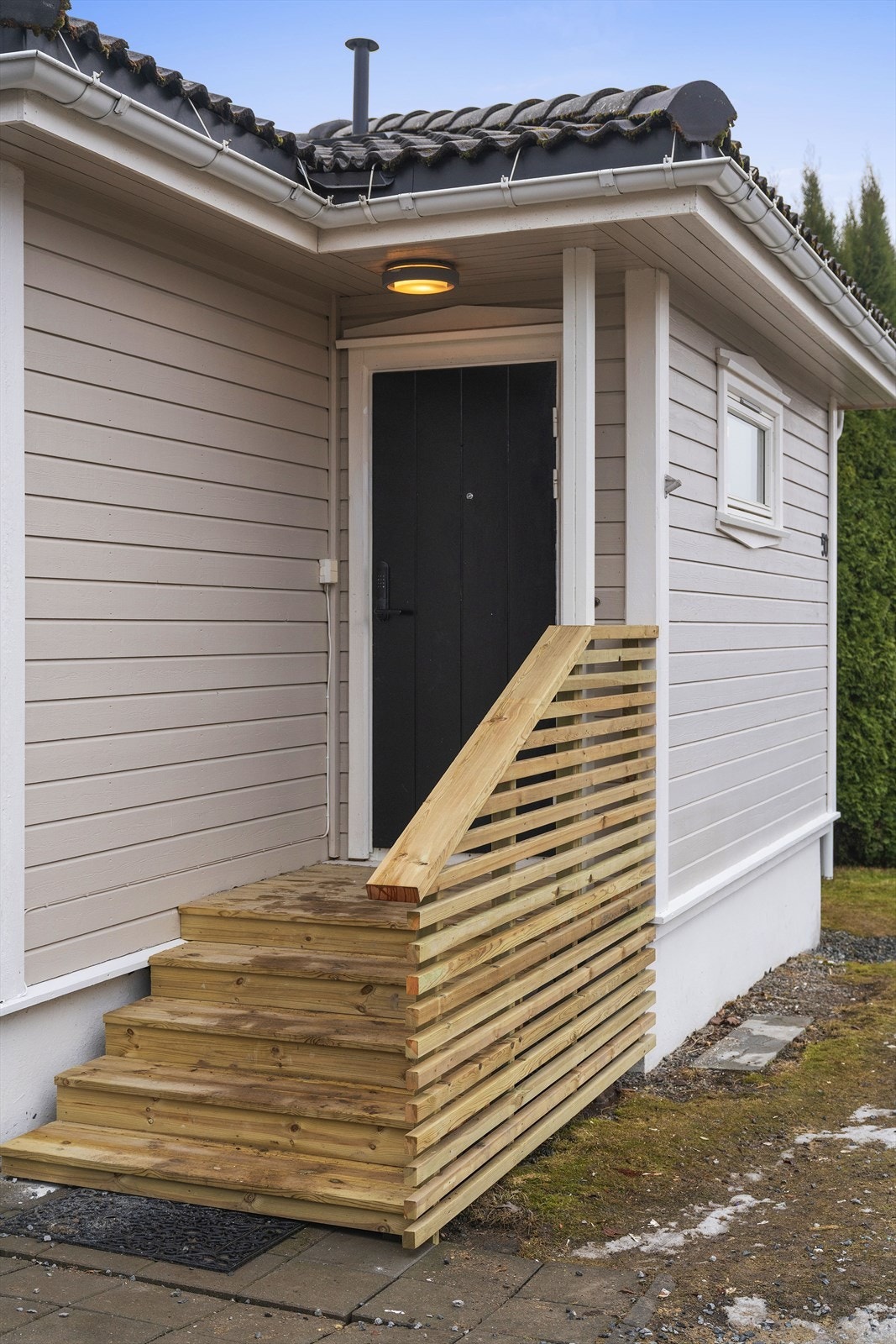 Boligen har et hyggelig inngangsparti med ny trapp i impregnert trevirke, samt rekkverk med liggende spiler. Galleribilde