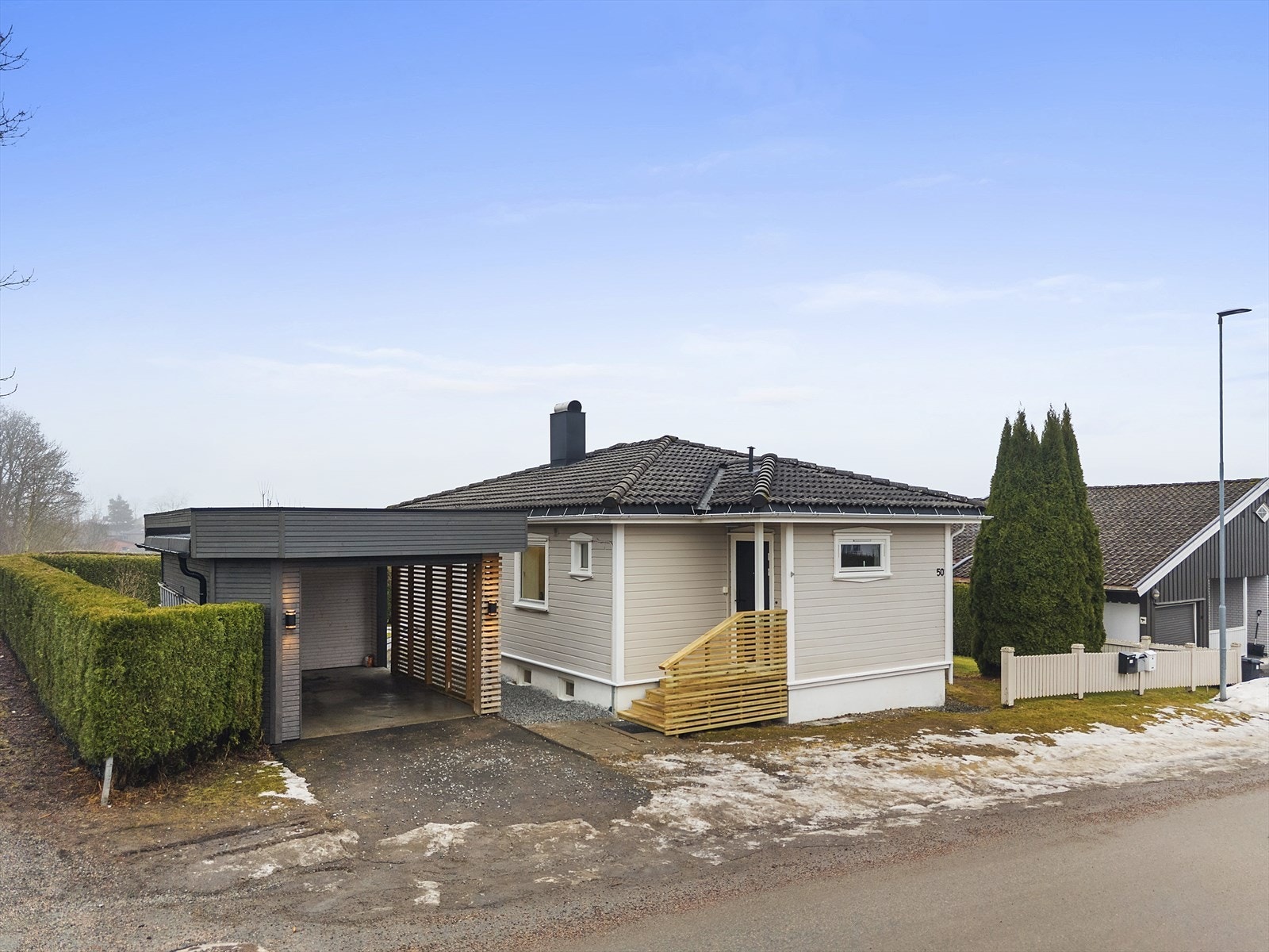 Romslig og pent opparbeidet tomt, med hyggelige uteplasser, gode solforhold og frittstående carport fra ca. 2023. Galleribilde