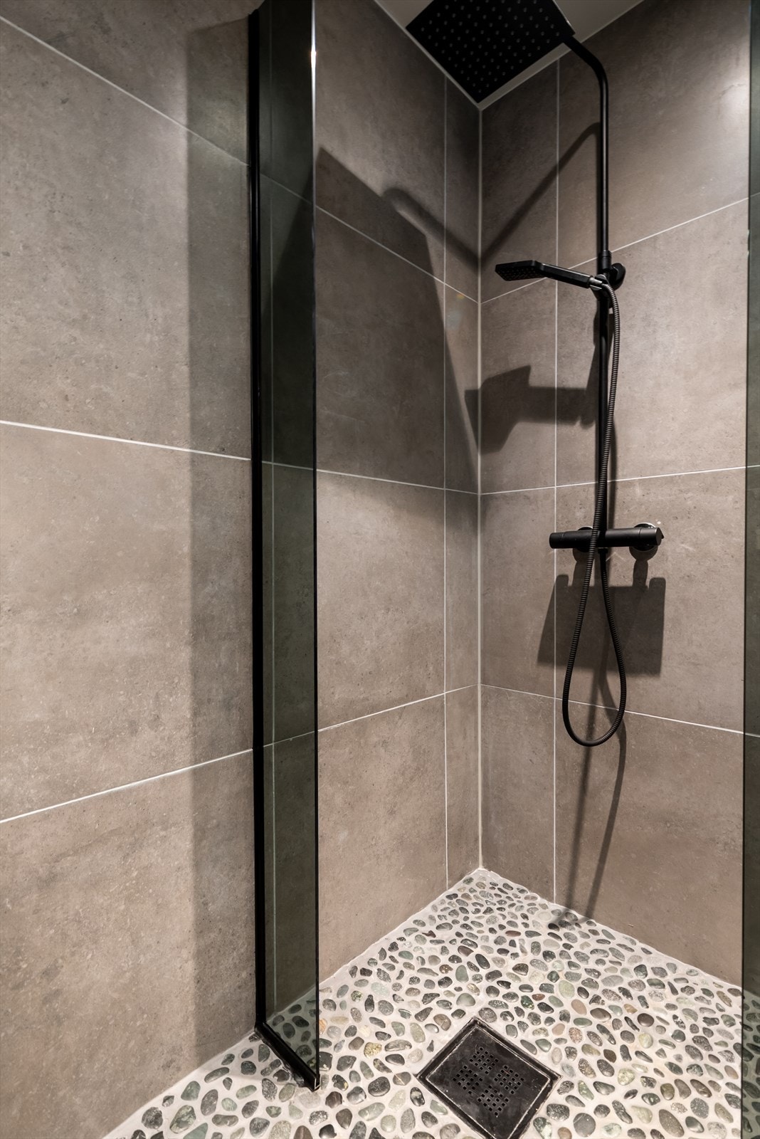 Flotte flisekombinasjoner med elvestein på gulvet, og rainshower som gir en behagelig spafølelse. Galleribilde