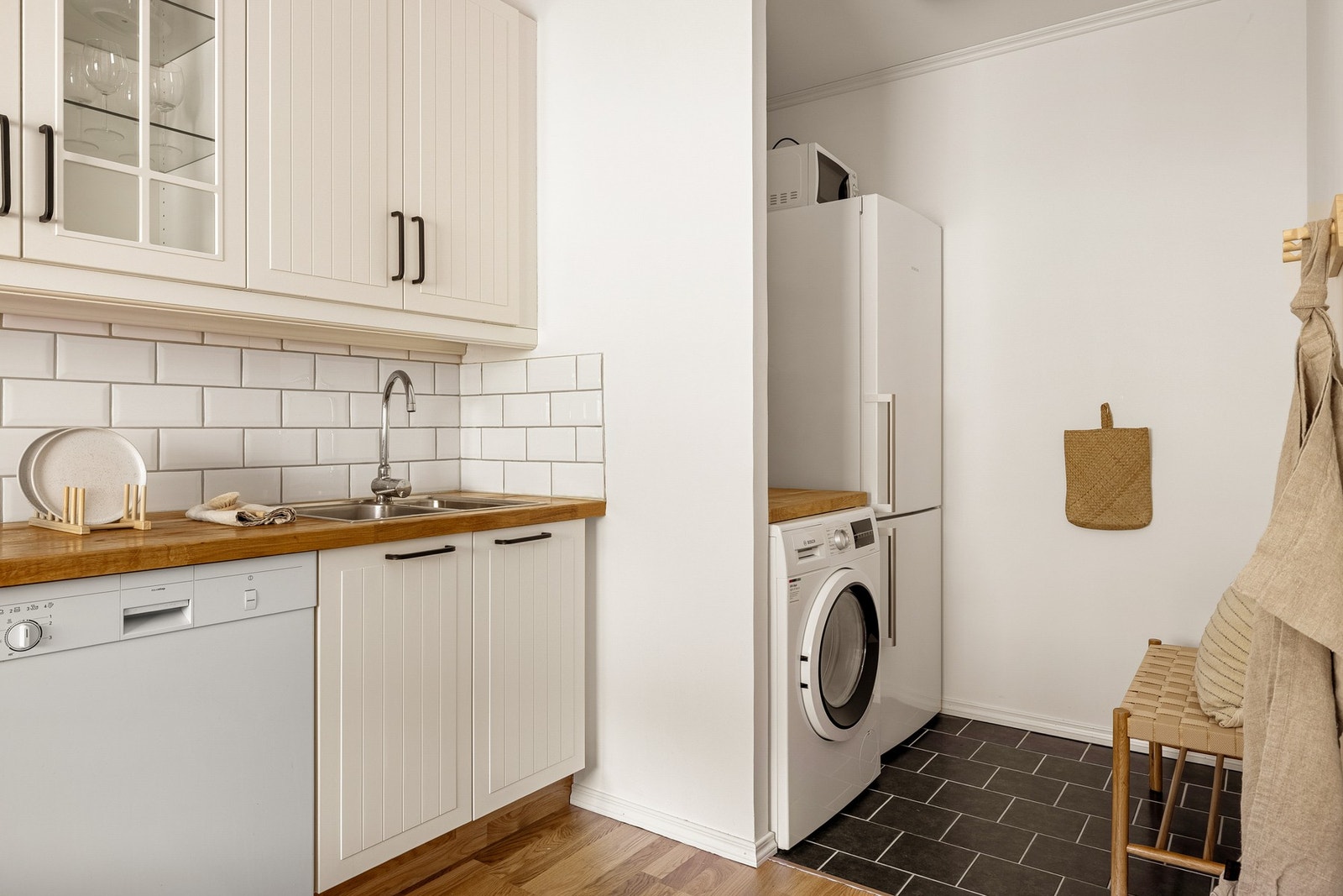 Kjøkkenet er også knyttet til et vaskerom med fliser på gulv og opplegg for vaskemaskin. Galleribilde