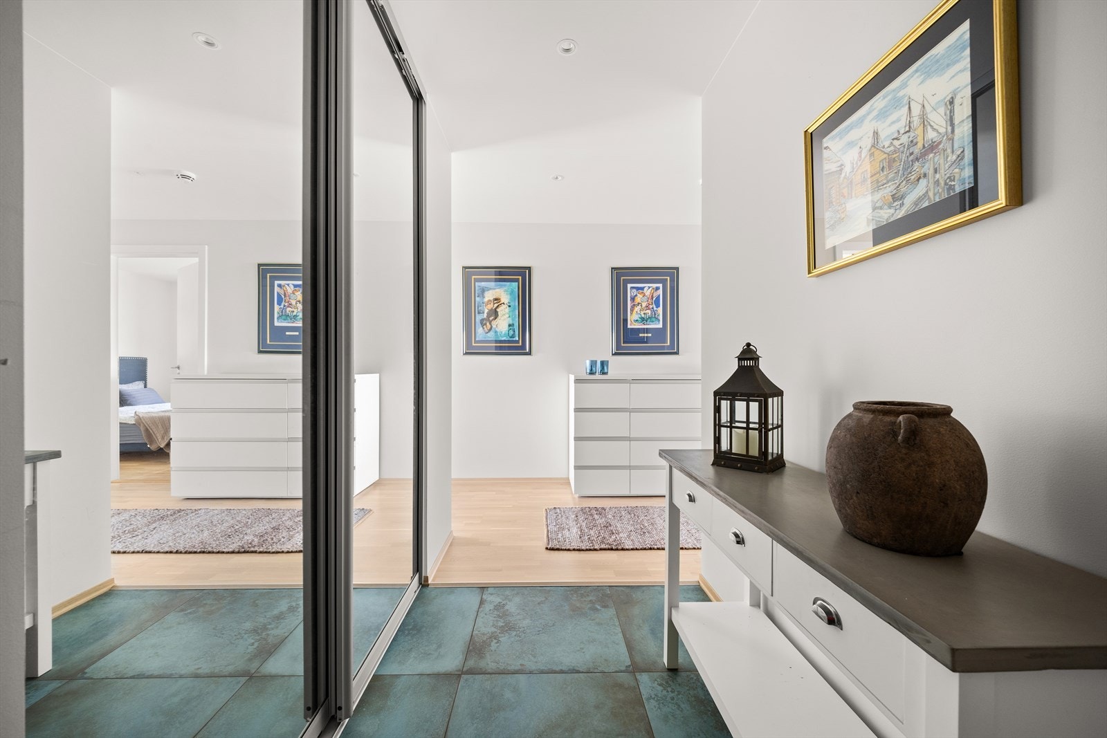 Inn i leiligheten kommer man til en praktisk flislagt hall med skyvedørsgarderobe Galleribilde