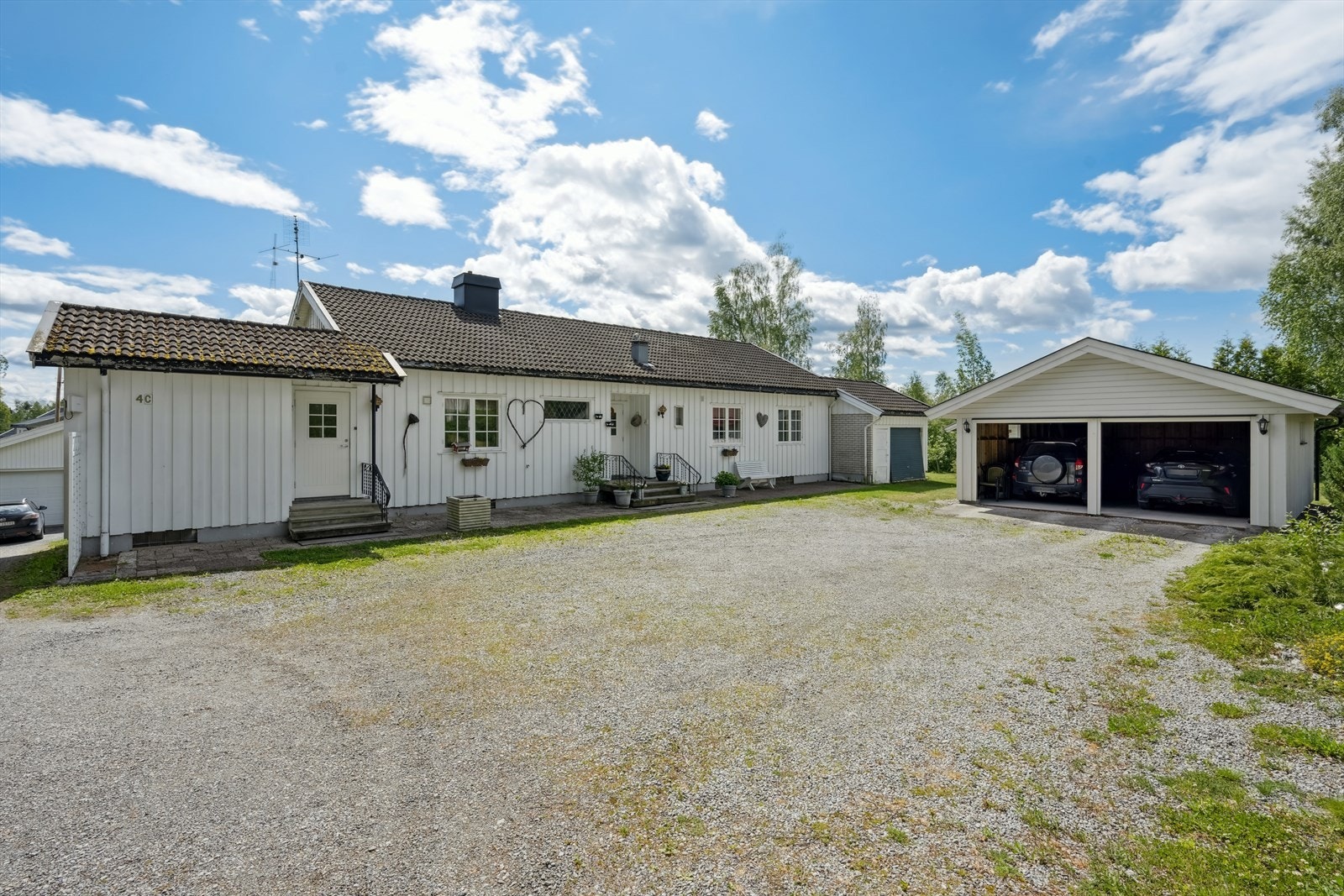 Stor, gruslagt gårdsplass med rikelig med biloppstillingsplasser. Galleribilde