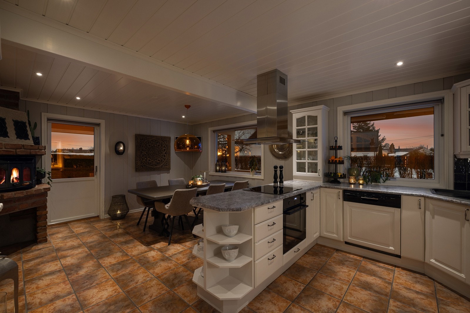 Kjøkkenet har en klassik stil praktisk innredet i en U-løsning med hvit, profilert innredning og vitrineskap. Galleribilde