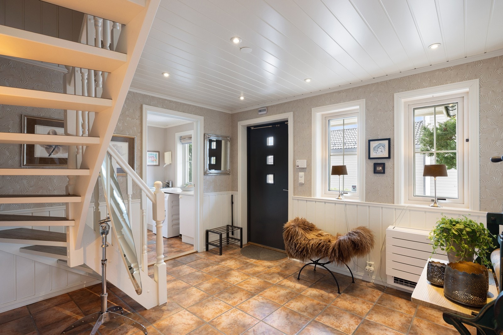 Førsteinntrykket innvendig er lyst og stilfullt. Entréen er preget av klassiske detaljer som hvitmalt brystningspanel kombinert med en delikat tapet. Galleribilde