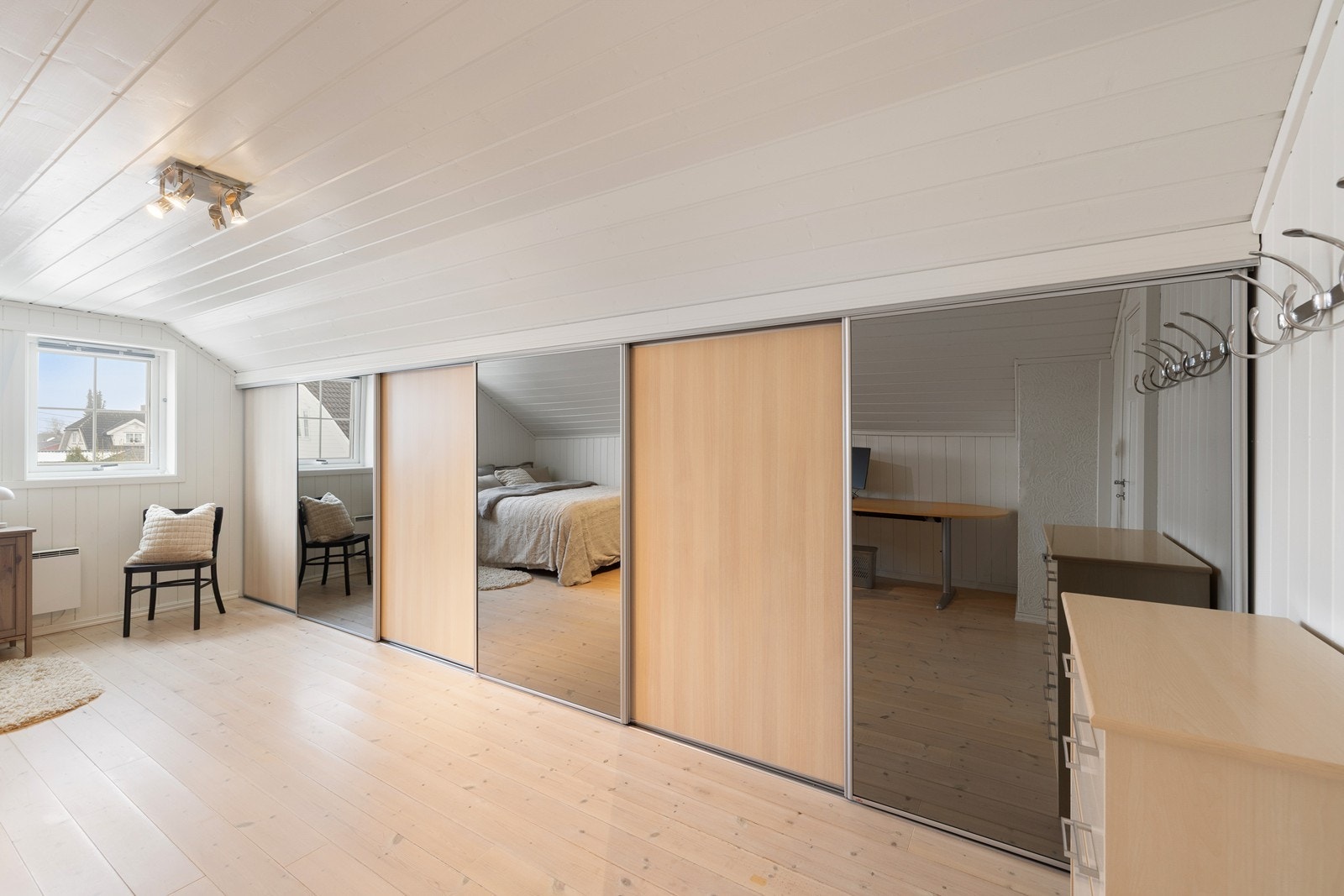 Rommet har en innebygget skyvedørsgarderobe for ekstra lagring i kneveggen. Galleribilde