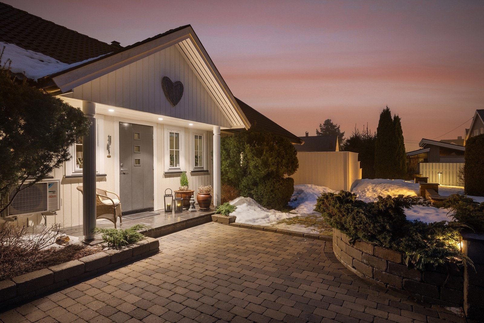 Her ønskes du velkommen av et flott steinbelagt inngangsparti, omkranset av stilfulle murer og integrert belysning som skaper en lun og trygg atmosfære. Galleribilde