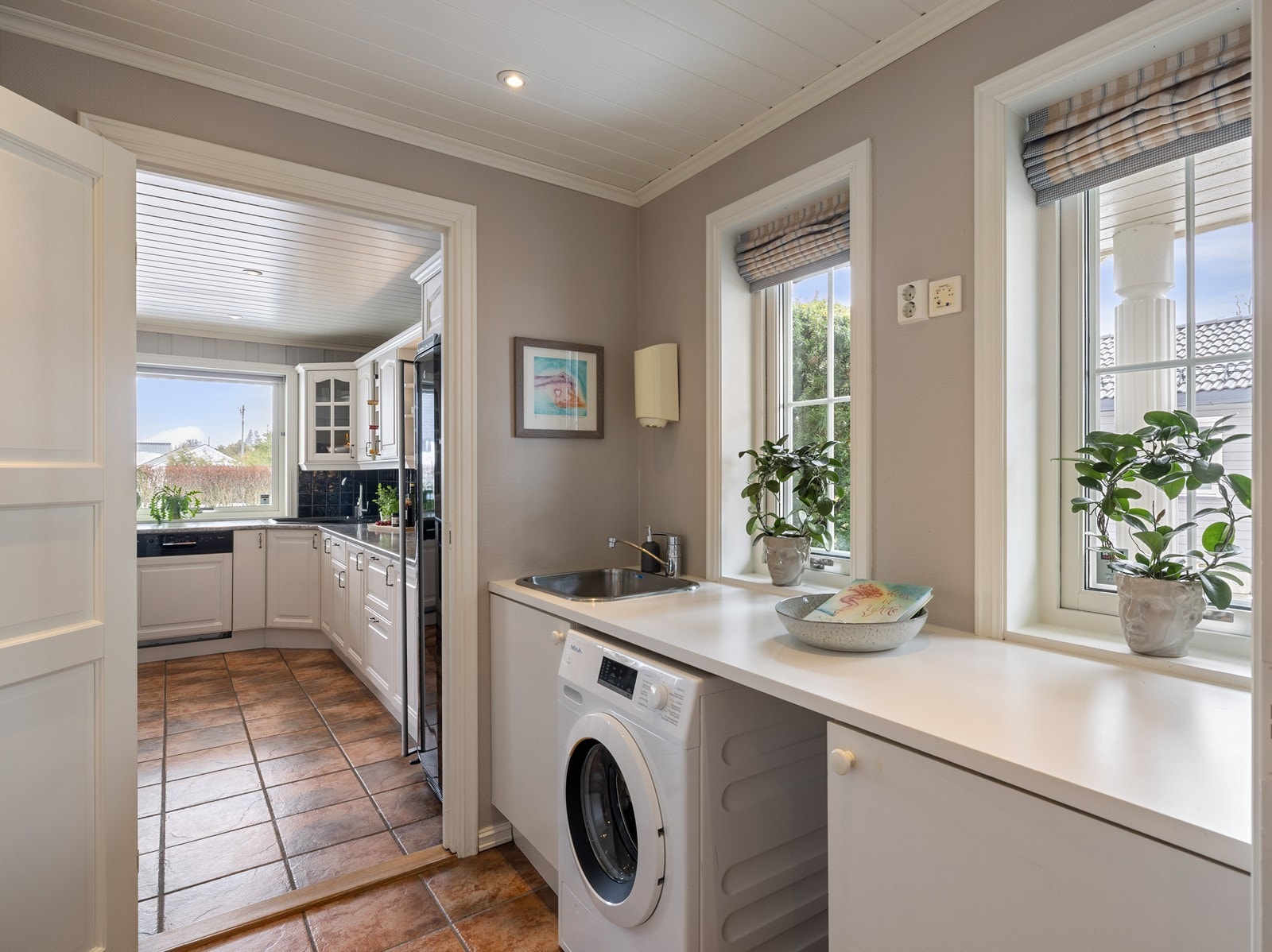 I direkte tilknytning til kjøkken og entré ligger et funksjonelt vaskerom. Rommet er utstyrt med lang arbeidsbenk, nedfelt vaskekum og opplegg for vaskemaskin. Galleribilde