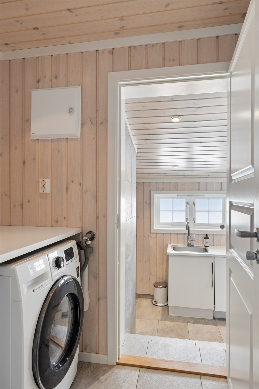 Vaskerom med fliser på gulv og panel på vegger og i himling. Galleribilde