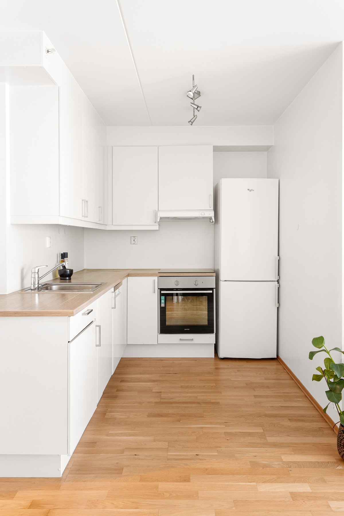 Lys, slett innredning med laminat benkeplate og nedfelt kum med ett-greps armatur. Galleribilde