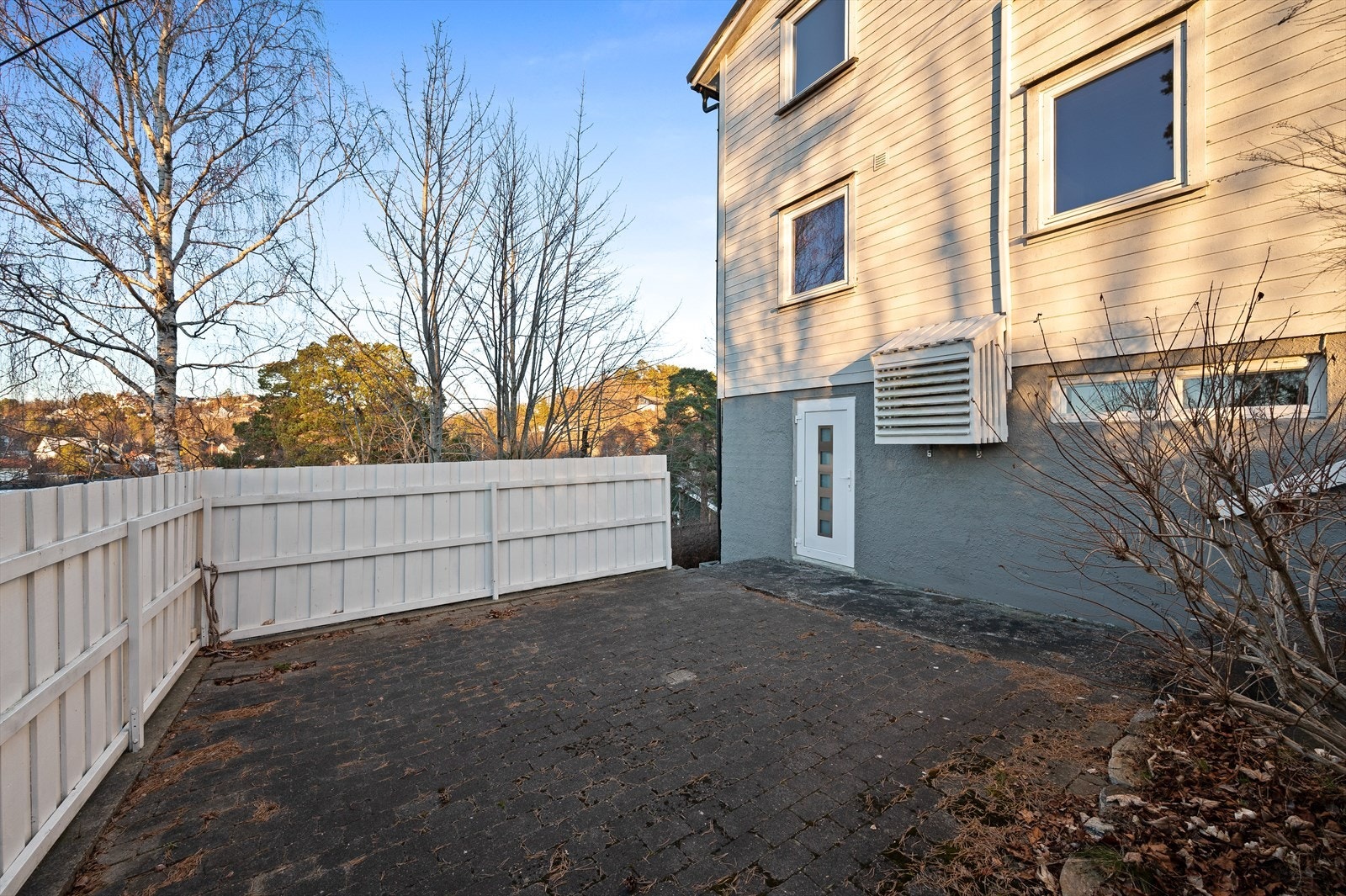 Steinbelagt uteplass med gjerde rundt Galleribilde