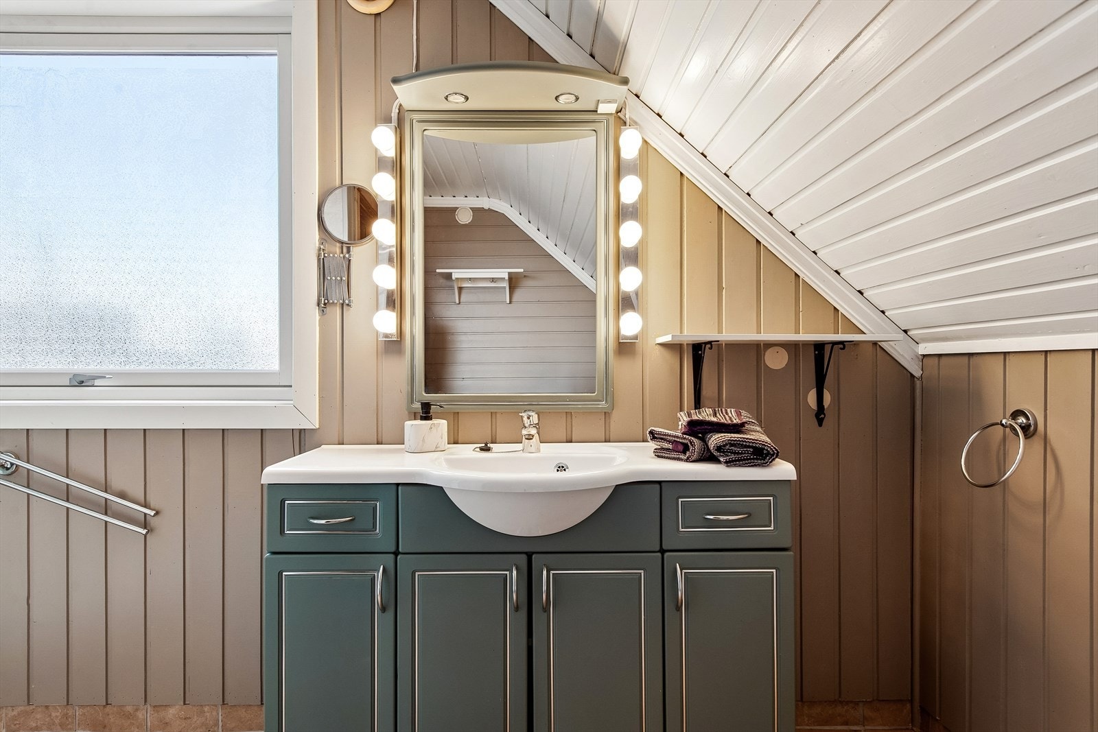 Innredningen har profilerte fronter, heldekkende servant og speil med belysning. Galleribilde