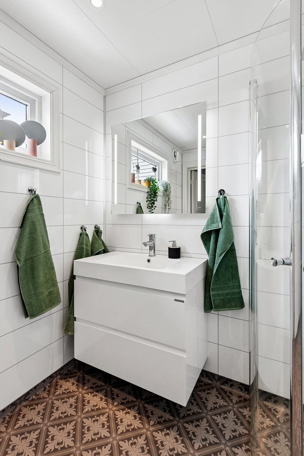 Innredningen består av slette fronter, heldekkende servant og speil med integrert lys. Galleribilde