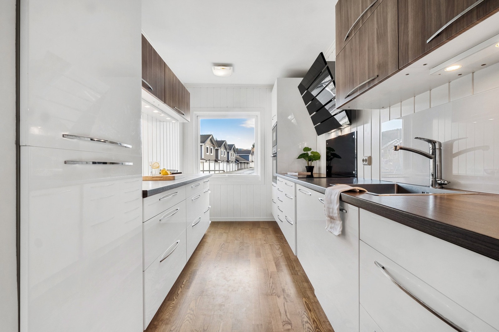 Tidløs kjøkkeninnredning med glatte fronter og god skap- og benkeplass. Benkeplate i laminat og integrerte hvitevarer Galleribilde