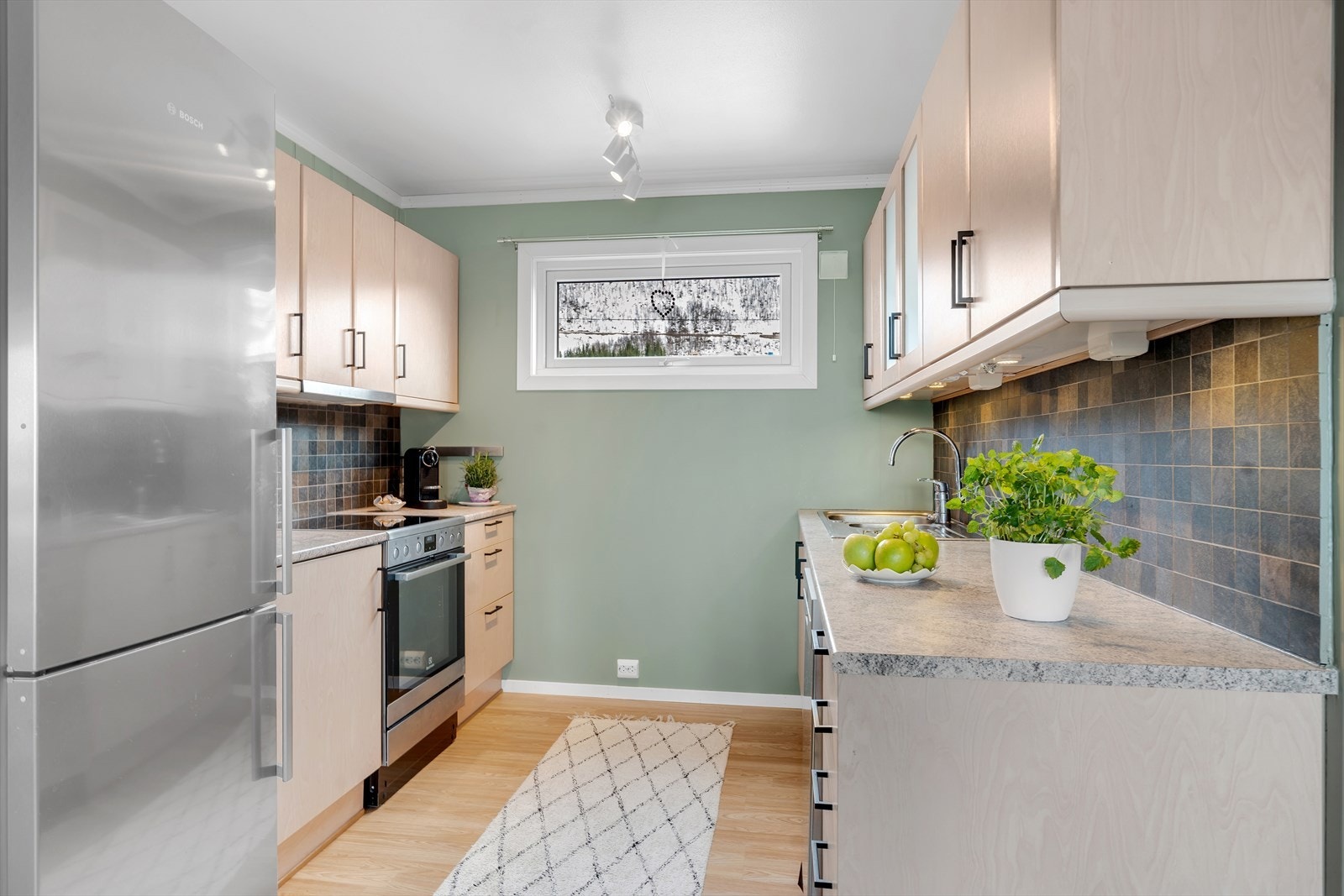 Fint kjøkken med mye skap- og benkeplass Galleribilde