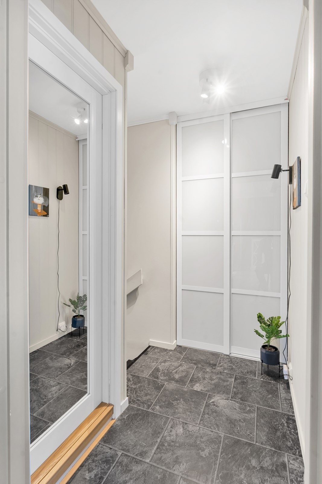 Inngang i første plan. Trapp opp til gang med garderobe Galleribilde