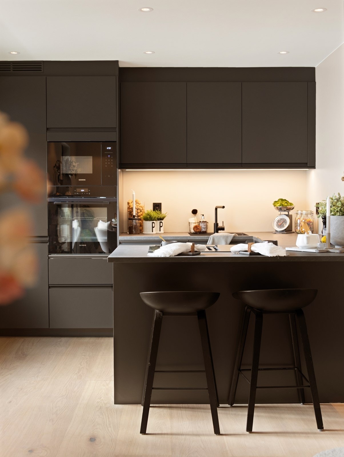 En praktisk bardisk gir sitteplasser og skaper en sosial sone hvor gjester kan delta under matlagingen. Galleribilde