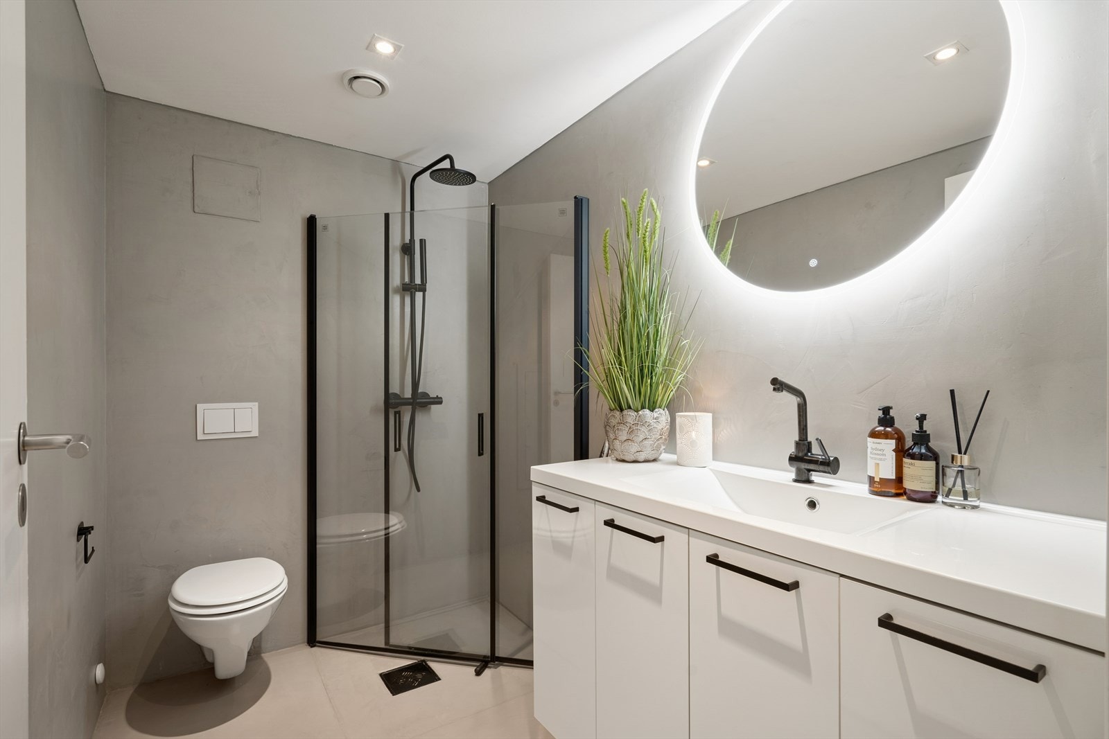 Mikrosement på vegger og gulv gir et moderne uttrykk, med elektriske varmekabler for komfort. Galleribilde