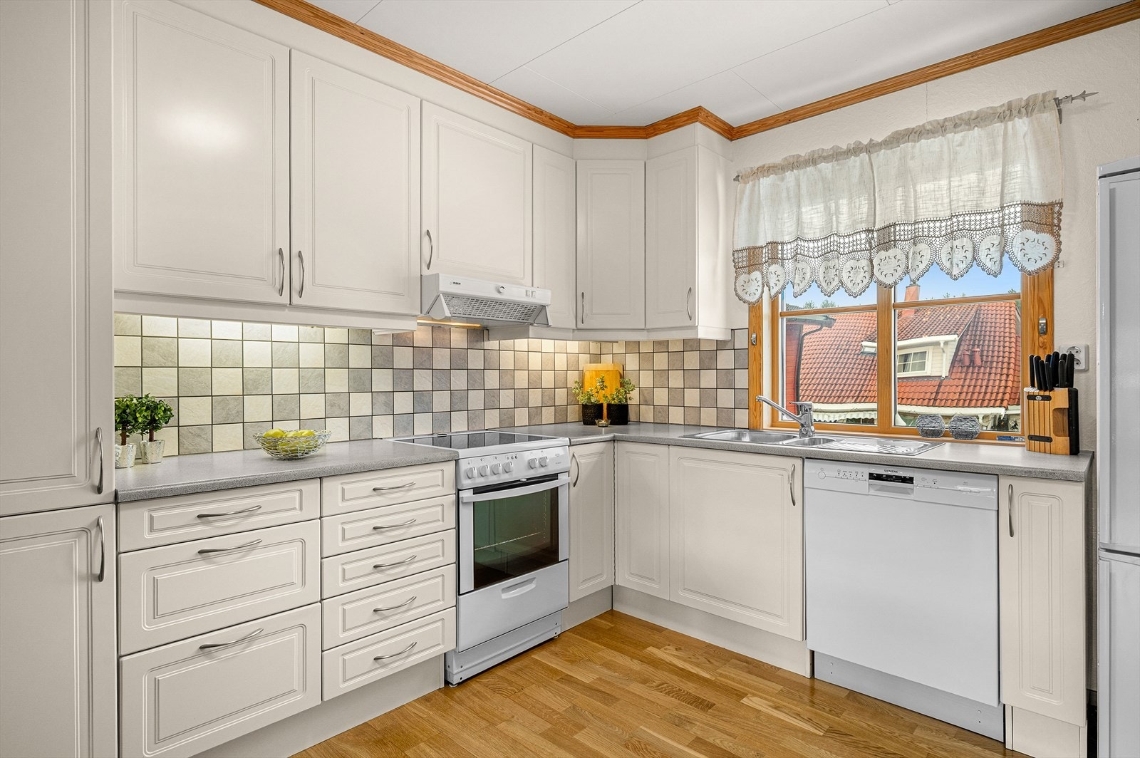 Kjøkkenet har en hvit og klassisk innredning med profilerte fronter og rikelig med skapplass. Galleribilde