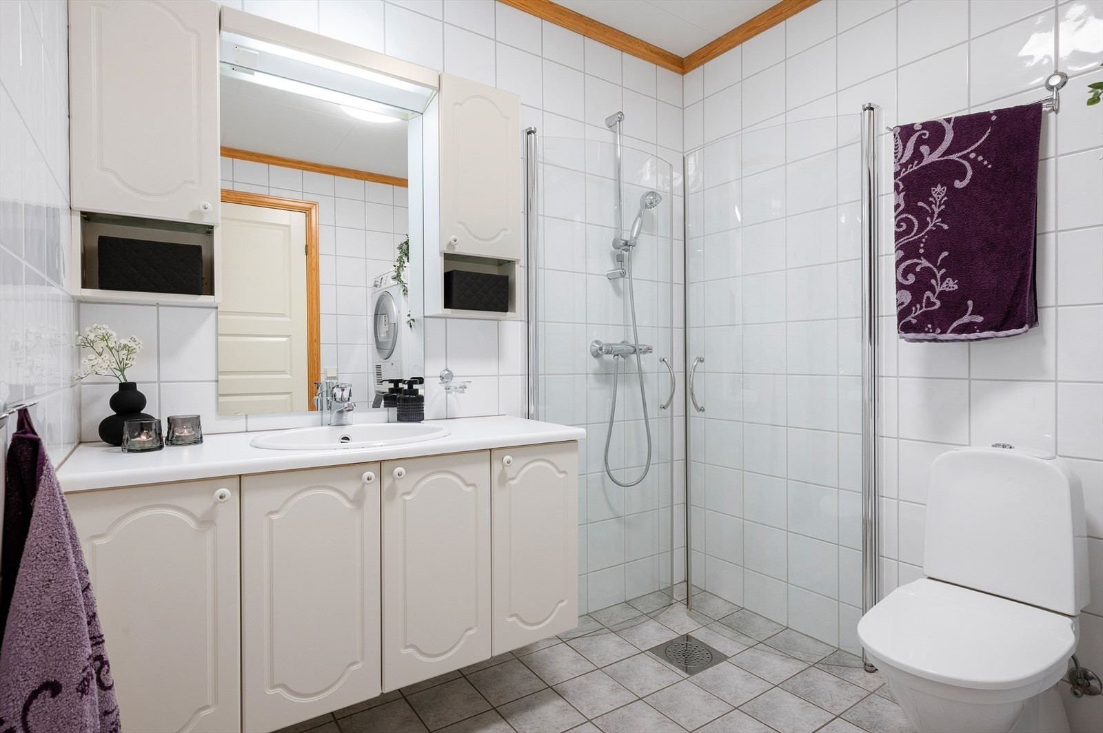 Flislagt bad på 5 m² med praktisk baderomsinnredning som gir gode oppbevaringsmuligheter. Galleribilde