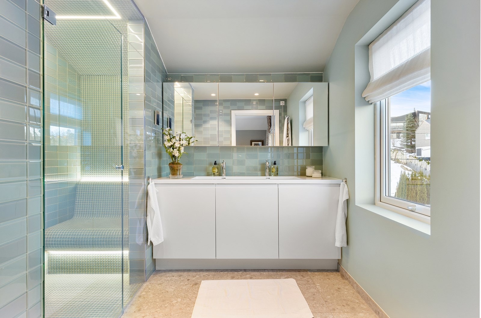Lekkert og romslig bad med delikate lysegrønne glassfliser fra Steinprosjekt og dobbel servant i korian. Galleribilde