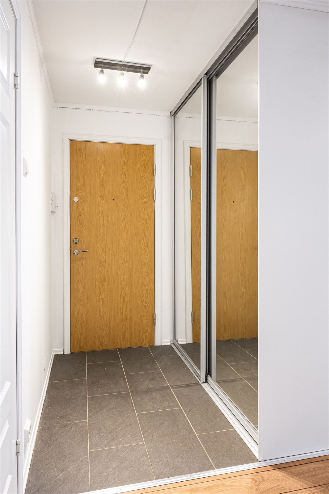 En romslig skyvedørsgarderobe med speilfronter gir rikelig med oppbevaringsplass for yttertøy og sko. Galleribilde