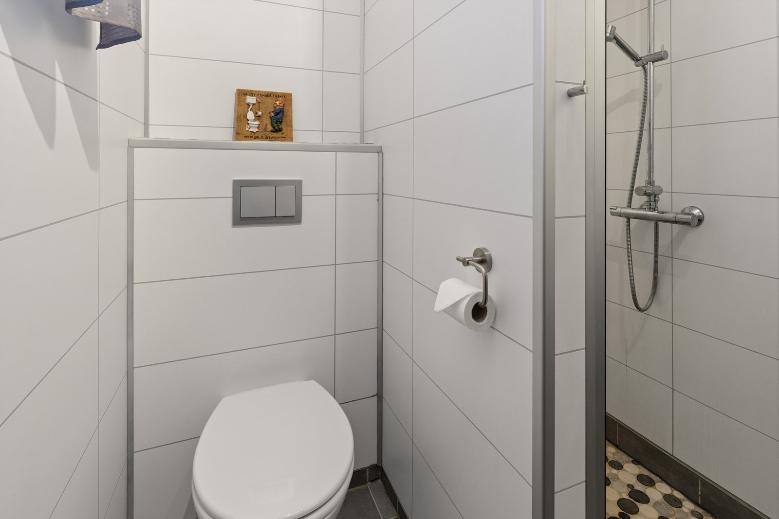 Badet har flislagte overflater på gulv og baderomsplater på vegger. Galleribilde