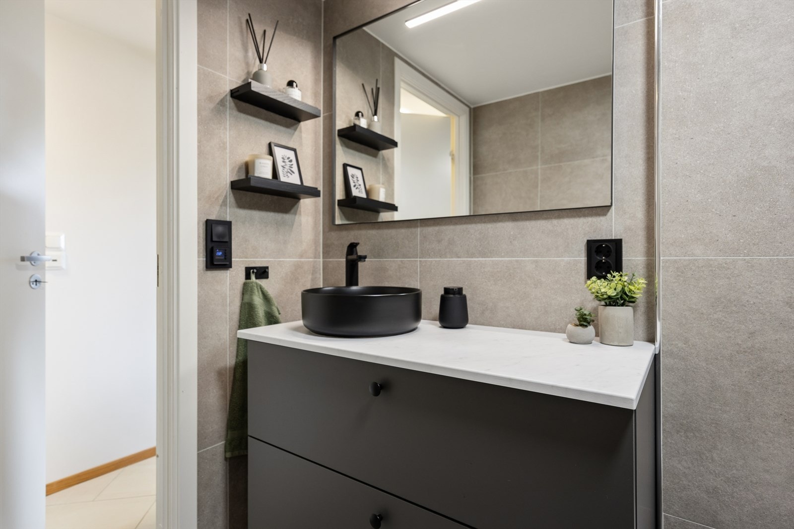 Badet er utstyrt med vegghengt toalett, dusjhjørne med glassvegger og opplegg for vaskemaskin. Galleribilde