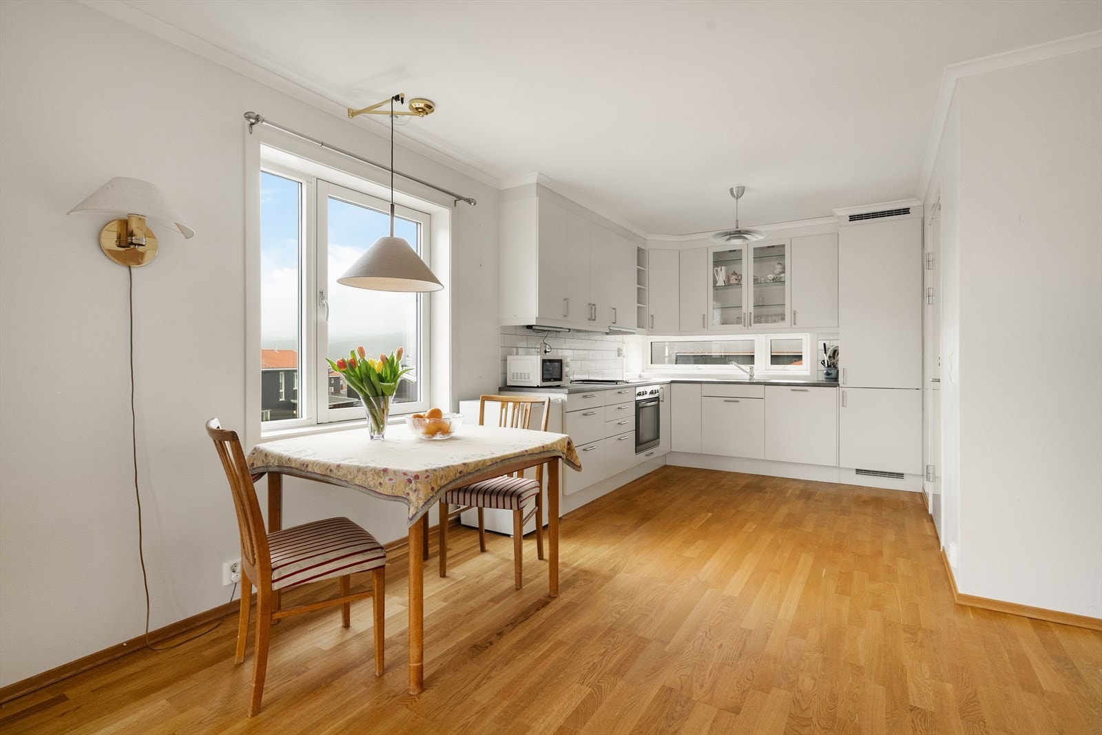 I tilknytning til kjøkkendelen er det plass til et spisebord ved vinduet. Innredningen har slette, takhøye fronter og noe glassskap, laminat benkeplate og flis over deler av kjøkkenebenk. Galleribilde