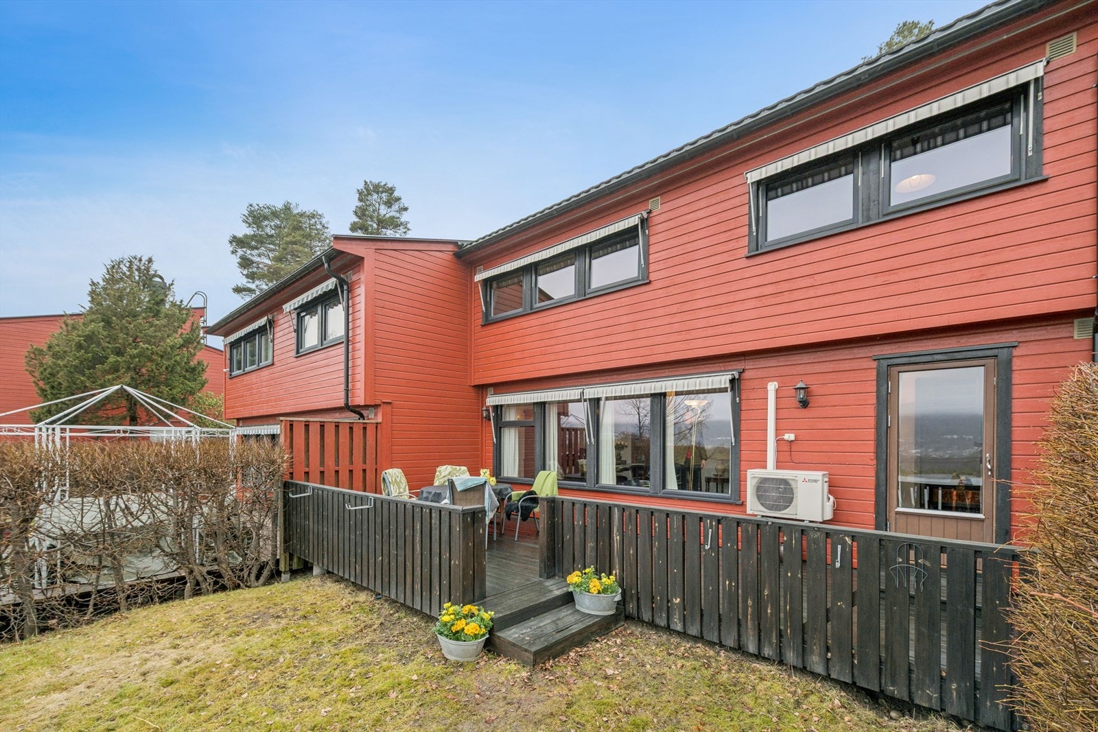 Adkomst fra stue til koselig uteplass med terrasseplatting og hage Galleribilde