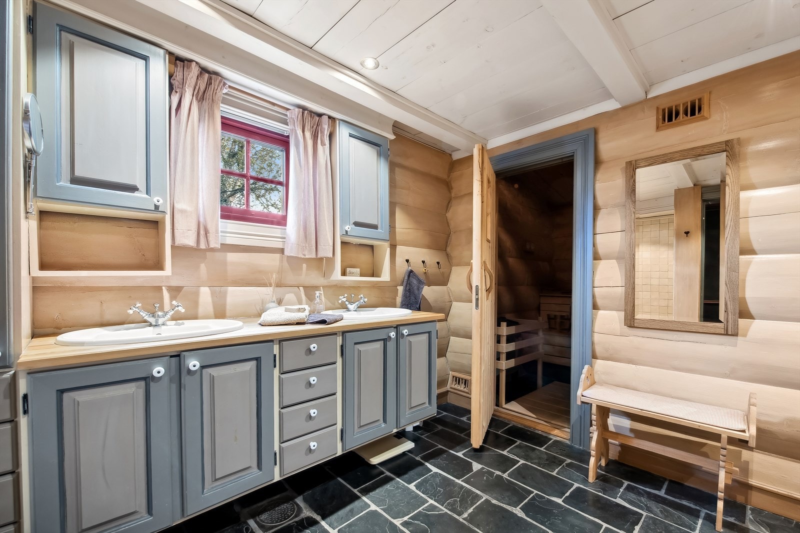 Veggene i badet forøvrig er kledd med tømmer, som gir en autentisk fjellfølelse, mens himlingen er dekket med trepanel. Gulvet er belagt med skifer med varmekabler. Galleribilde