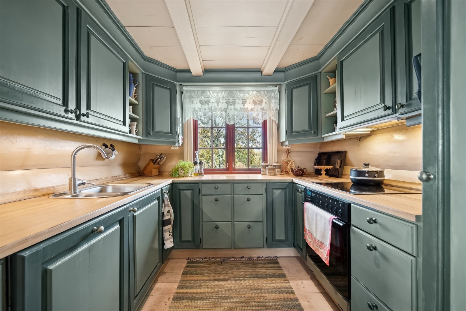 Flott heltre kjøkken med rikelig arbeids- og lagringsplass, utformet i en praktisk U-løsning som gir kokken et ideelt område å briljere med sine kulinariske ferdigheter. Galleribilde