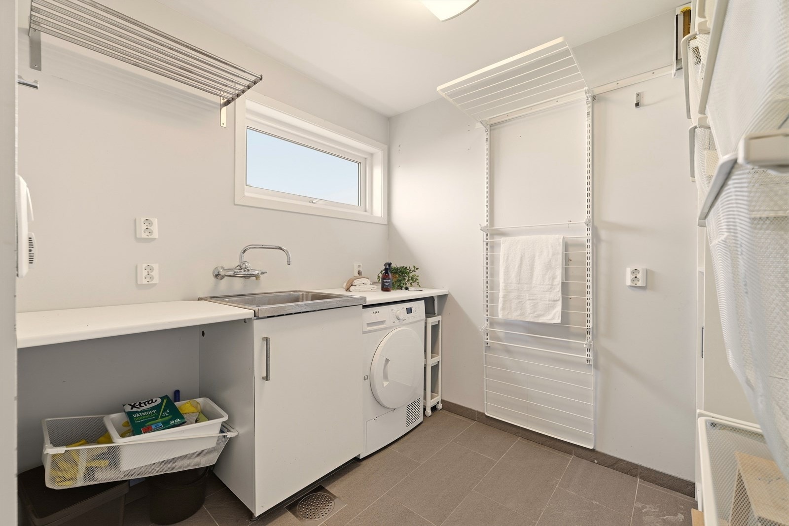 I hovedetasjen finnes også praktisk vaskerom. Vaskerommet har innredning med slette fronter, benkeplate i laminat, utslagsvask i stål, opplegg for vaskemaskin/tørketrommel, fordelerskap til rør-i -rør og div. hyller. Rommet har varme i gulv. Galleribilde