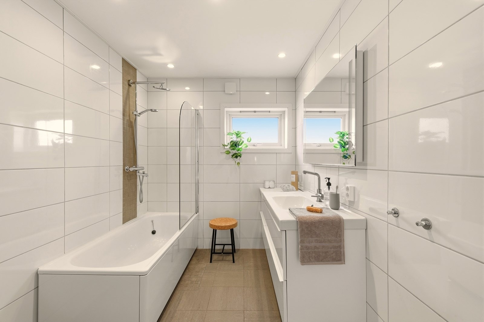 Baderom 2 befinner seg også i hovedetasjen og inneholder følgende: Baderomsinnredning med slette fronter, servant, speil med integrert belysning, vegghengt toalett og badekar med dusjgarnityr samt hånddusj. Galleribilde