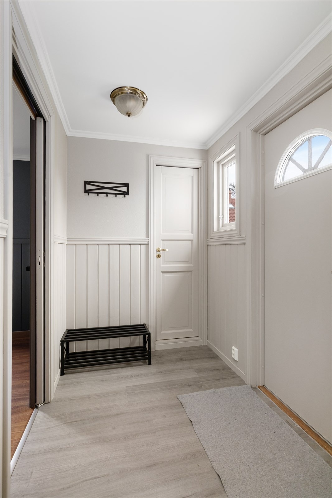 Lys og romslig entré i tilbygget del, med varmekabler i gulv og fin plass til oppbevaringsmøblement for sko- og yttertøy. Galleribilde