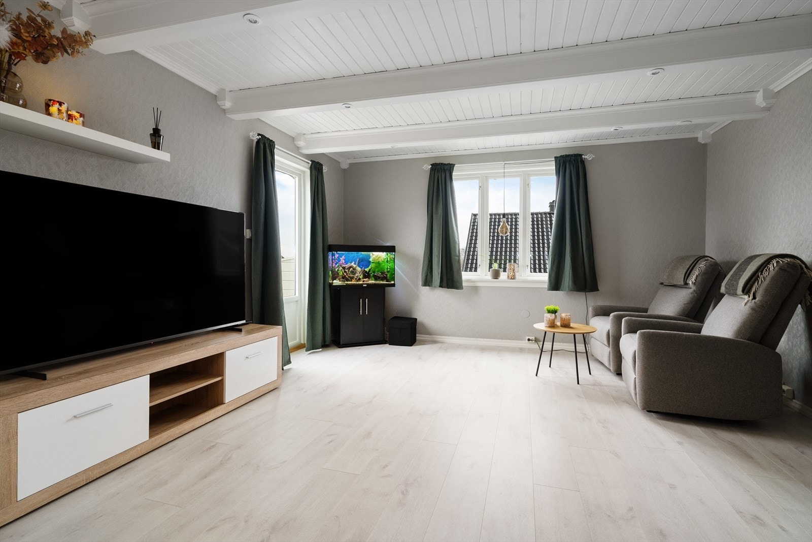 Romslig stue med fine overflater, god plass til sofagruppe og øvrig møblement, samt utgang til delvis overbygget veranda mot sydvest. Galleribilde