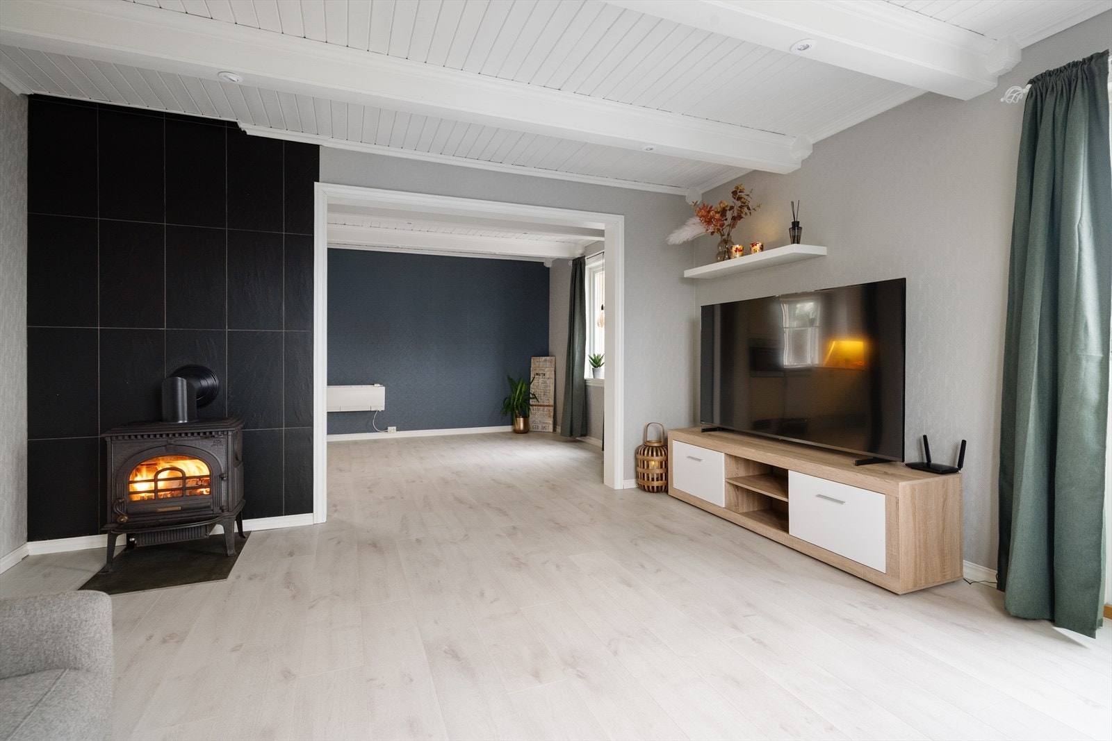 I stuen er det installert nyere vedovn med katalysator, utført som ufaglært arbeid i 2026. Boligen har murt pipe fra byggeår. Galleribilde