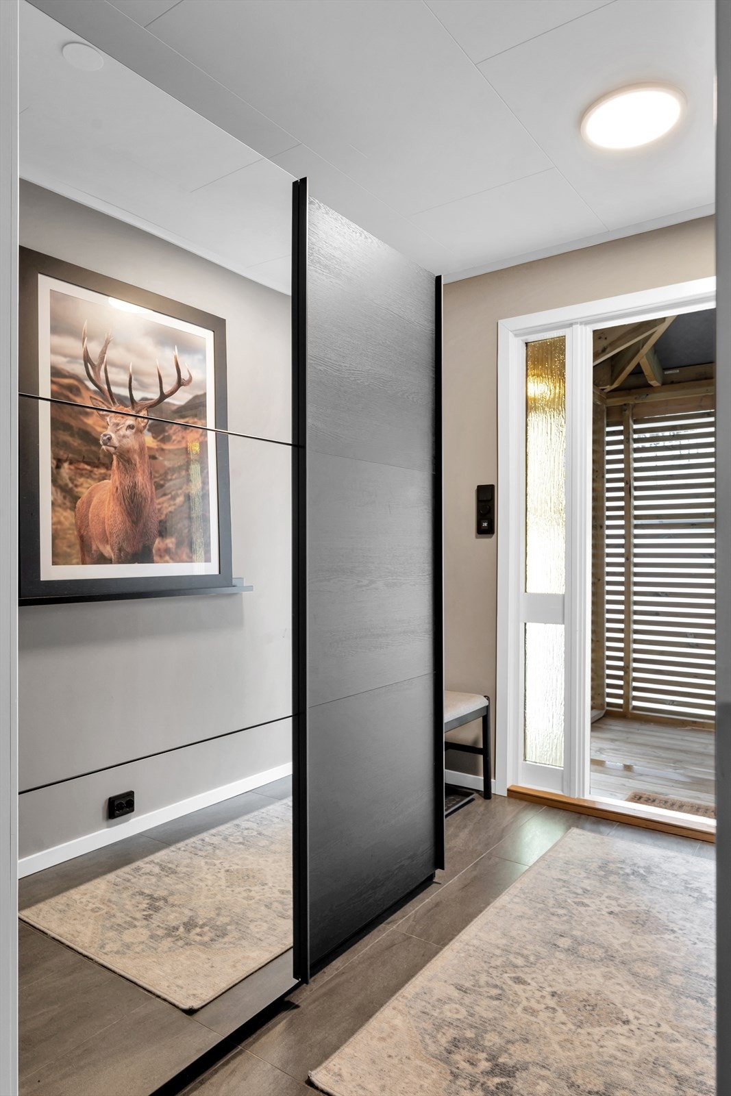 Flislagt og innbydende entre med rikelig plass til oppbevaring i skyvedørsgarderobe. Galleribilde